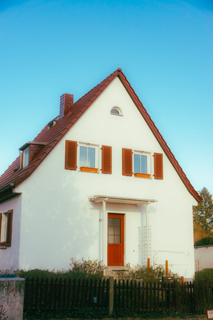 Einfamilienhaus mit roten Fensterläden und Satteldach